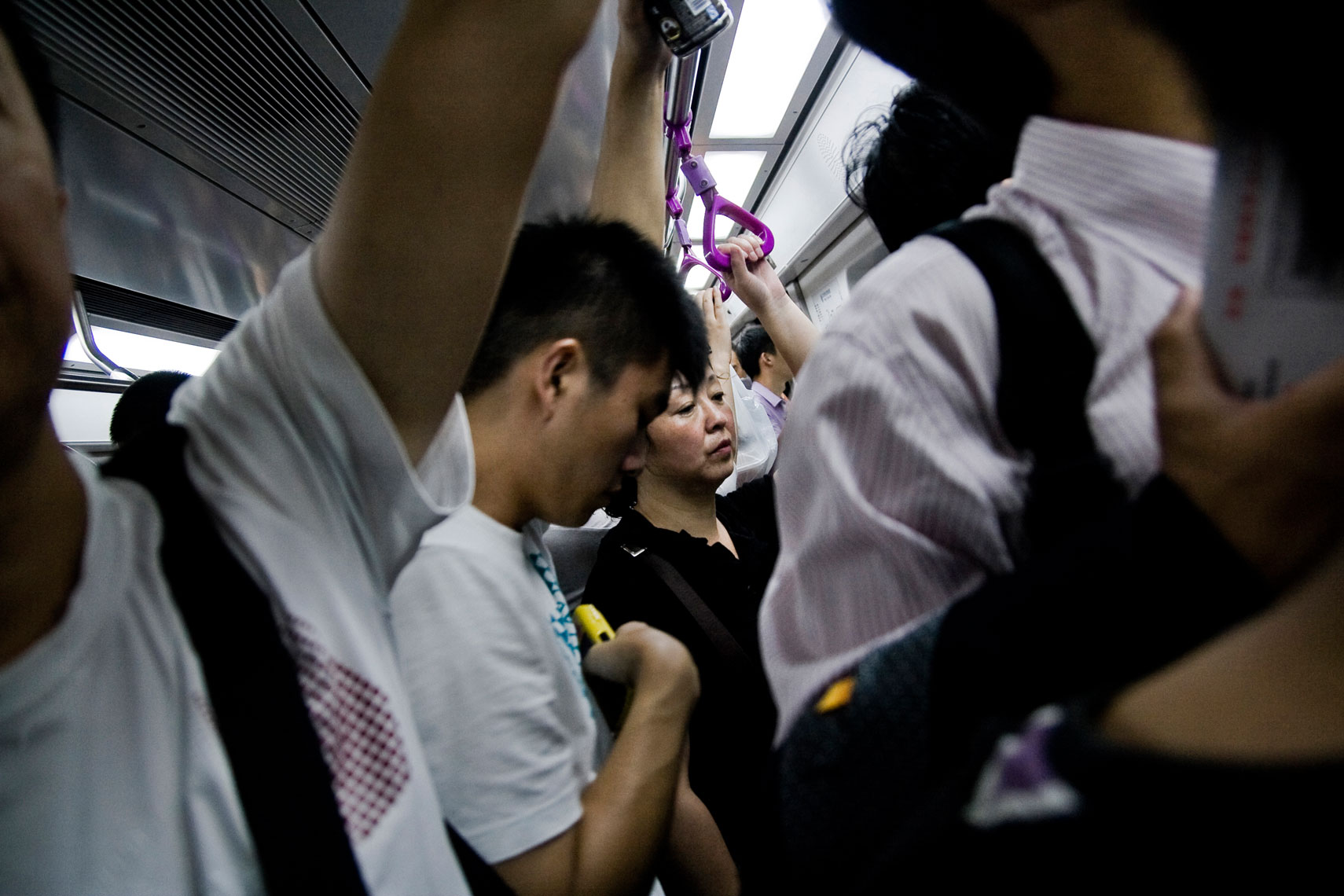 CHINA. Beijing, September 2012. People on a subway train.